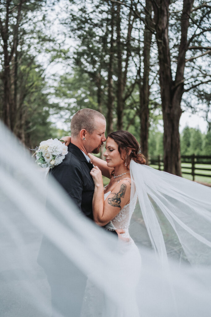 Beautiful veil bride and groom portrait. Groom is holding bride close to his chest during their bridal portraits. 
Quinn Photography LLC