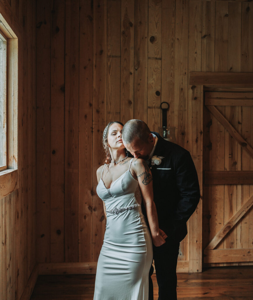 Groom kisses bride on her shoulder during the first look portion of the wedding day at Gentry Farm in Danville Virginia- Quinn Photography LLC