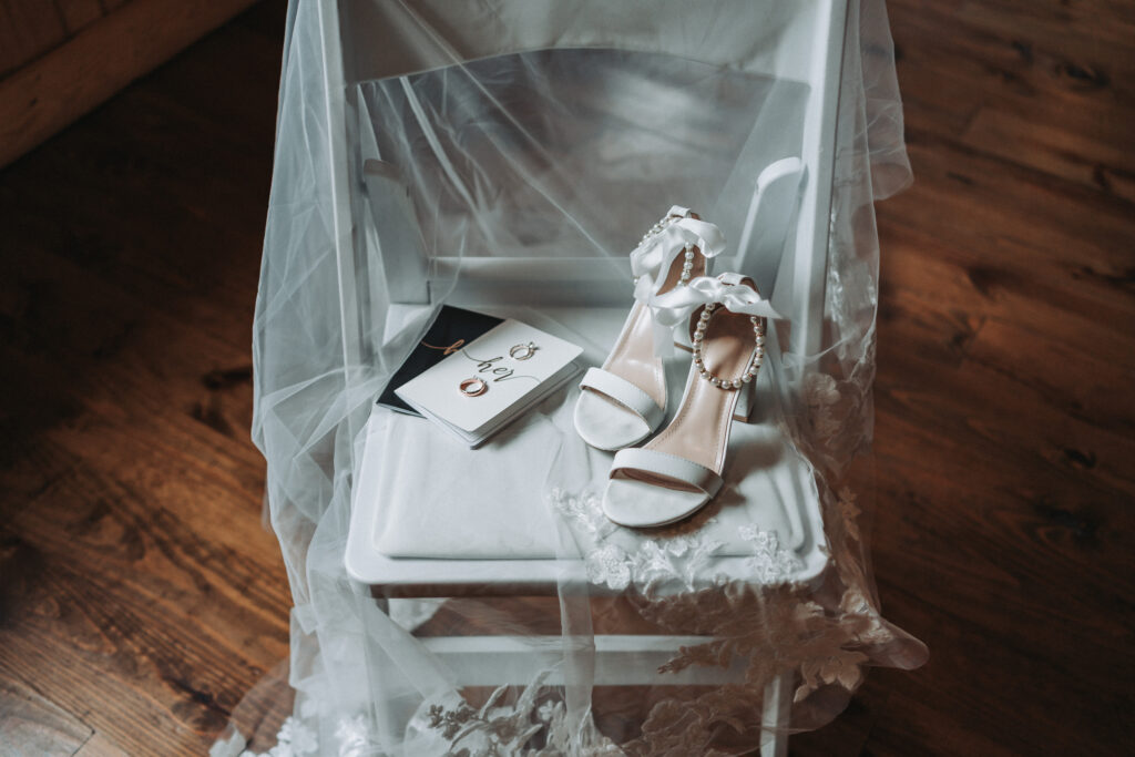 Detail photo of the brides accessories, featuring the rings and the vow books- Quinn Photography LLC