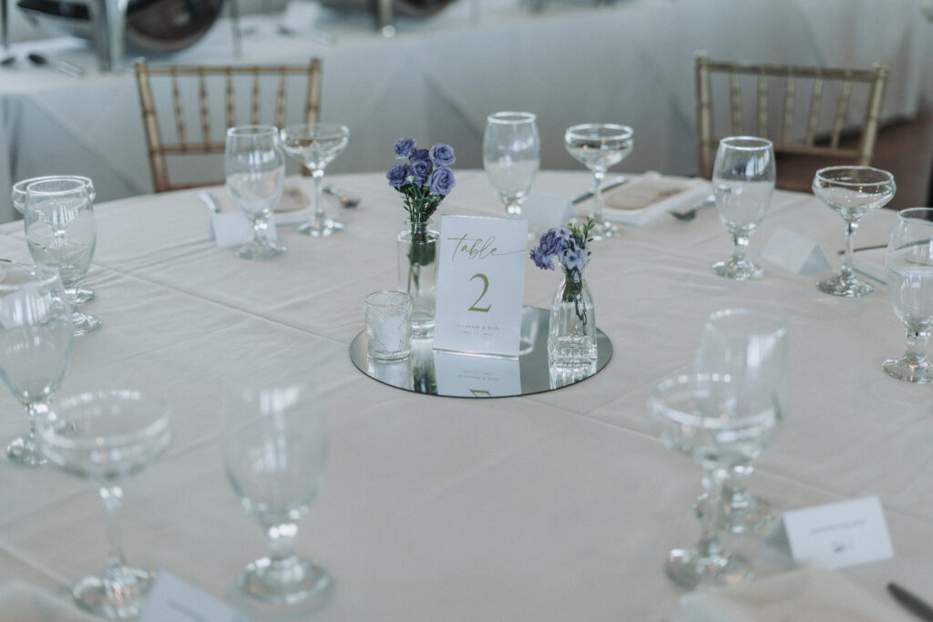 Table 2 centerpiece with soft lavender florals, clear glass vases, and mirrored base at the Lesner Inn.