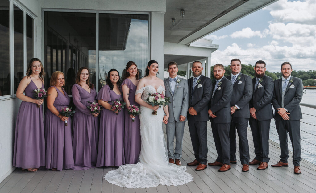 Full wedding party portrait with bridesmaids in lavender dresses and groomsmen in gray suits at Lesner Inn — captured by Quinn Photography LLC.