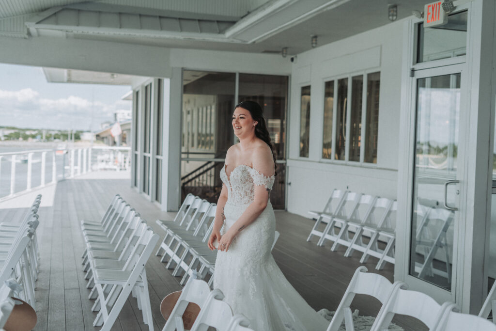 Bride walks through ceremony aisle setup on outdoor deck at Lesner Inn — photographed by Quinn Photography LLC.
