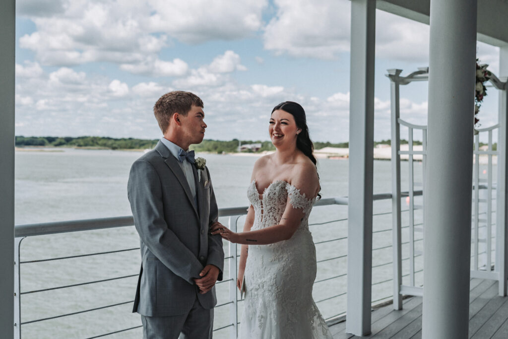 Bride and groom sharing a joyful first look on the balcony at Lesner Inn