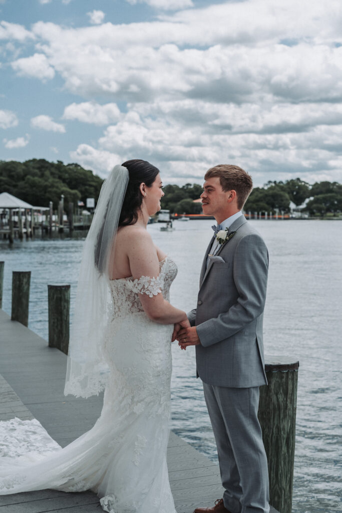 Bride and groom holding hands on the dock outside Lesner Inn