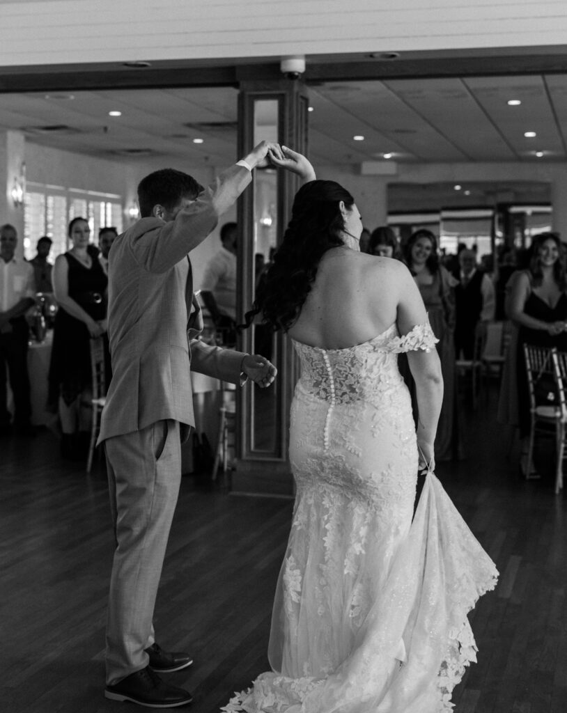 Black and white photo of bride being spun by groom during their first dance at Lesner Inn