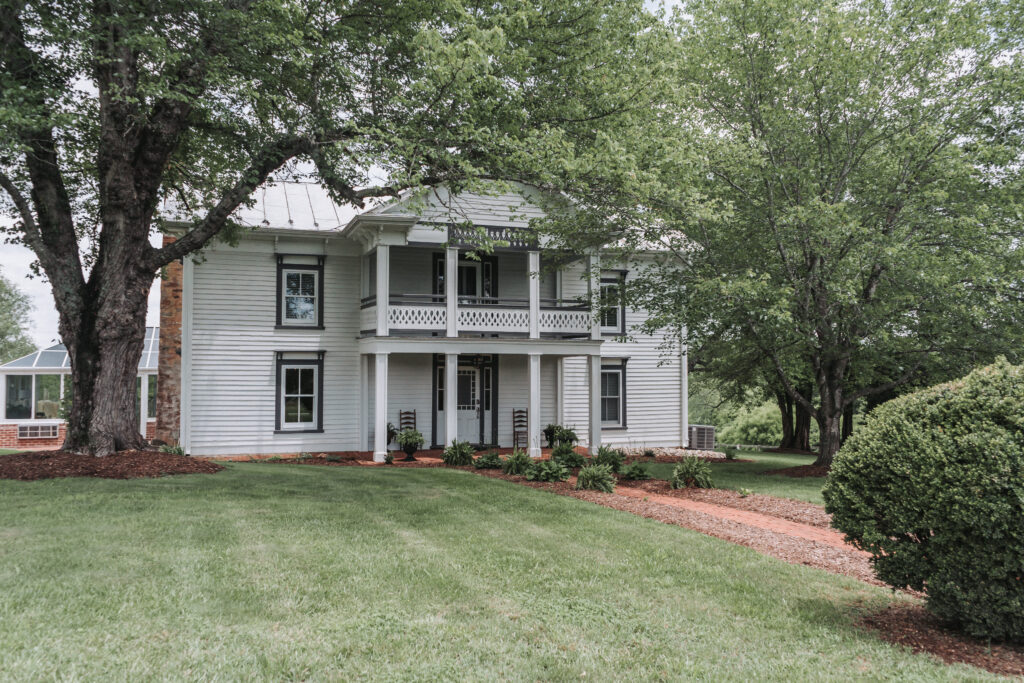 Historic white farmhouse surrounded by greenery at Due Sorelle.