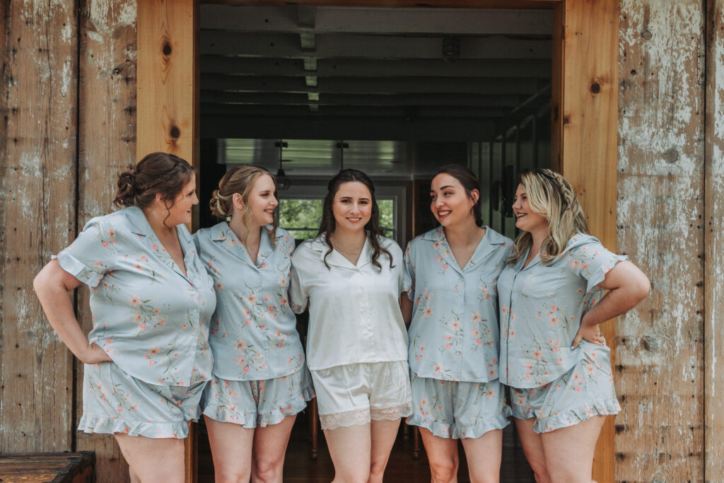 Bride stands with her bridesmaids in matching floral pajamas at Due Sorelle.