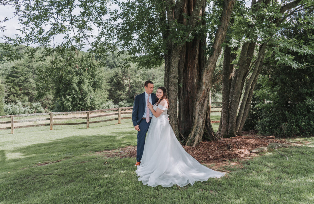 Bride and groom standing together under a large tree at Due Sorelle in Ruckersville, Virginia