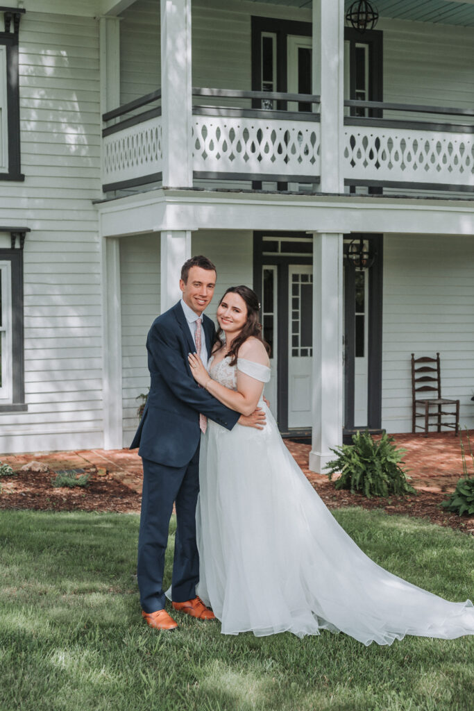 Bride and groom smiling in front of the farmhouse at Due Sorelle in Ruckersville, Virginia