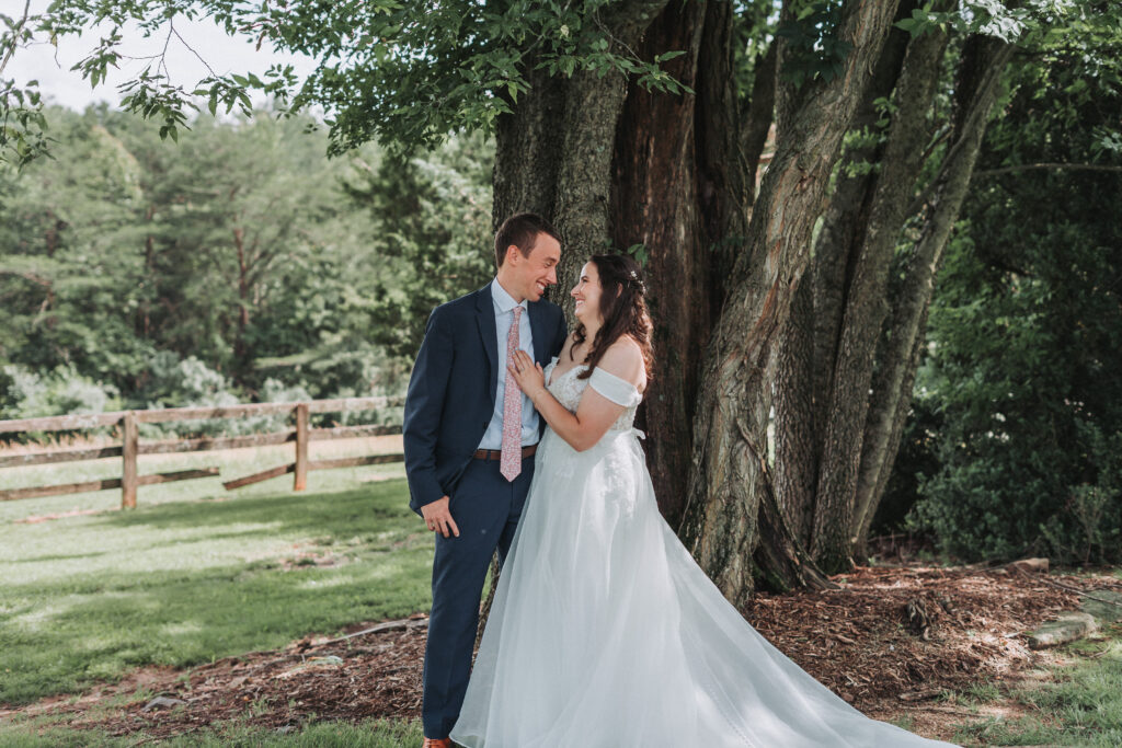 Bride and groom laugh under the trees at Due Sorelle in Ruckersville, Virginia.